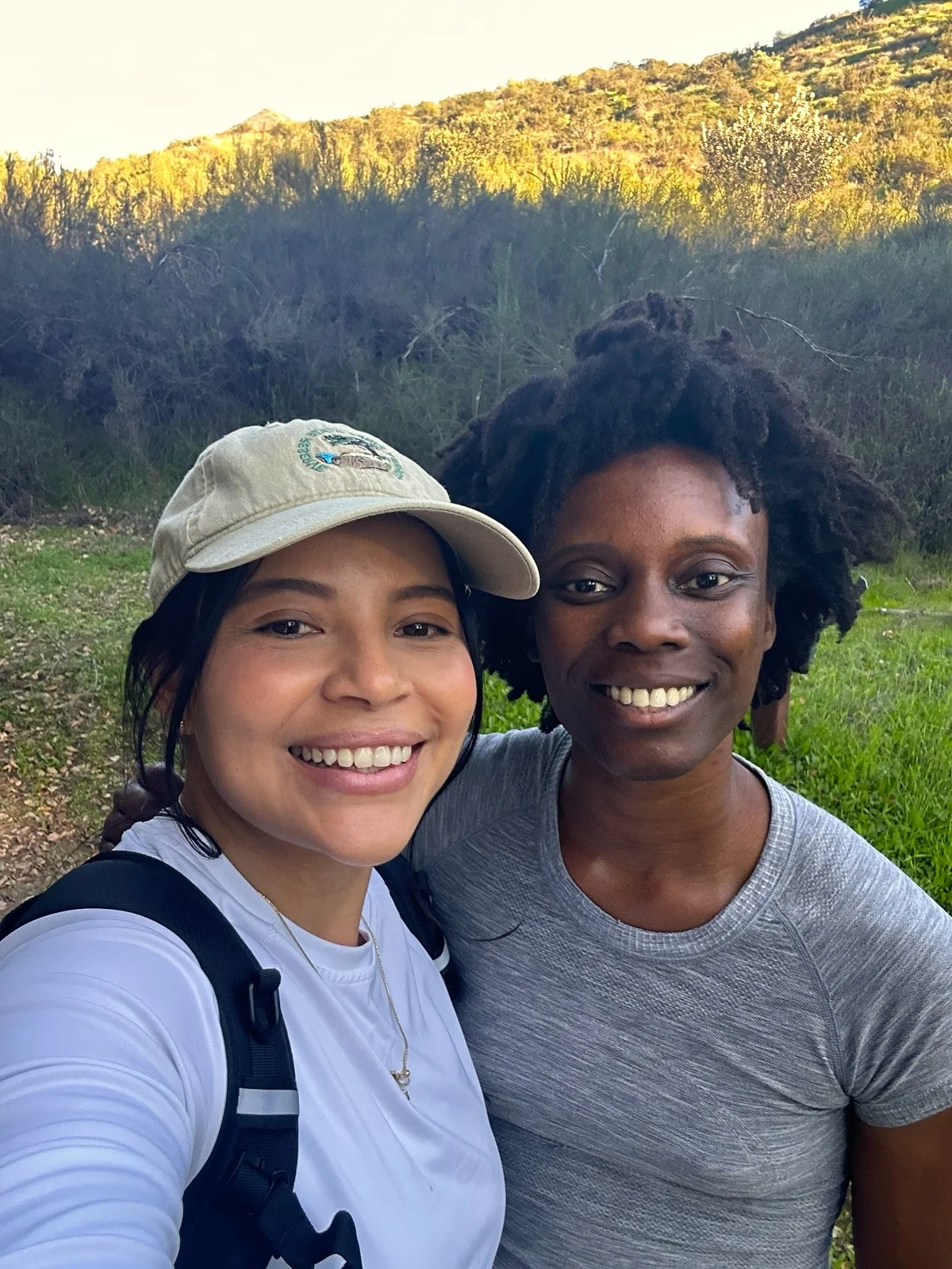 Oma's two founders smiling together on a hillside trail.
